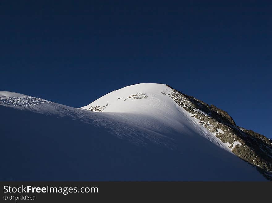 Alpine showy mountain ridge with clear sky. Alpine showy mountain ridge with clear sky