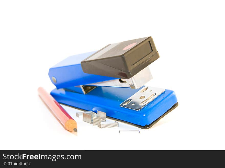 Single blue,chrome and black stapler with staples and pencil on a white background