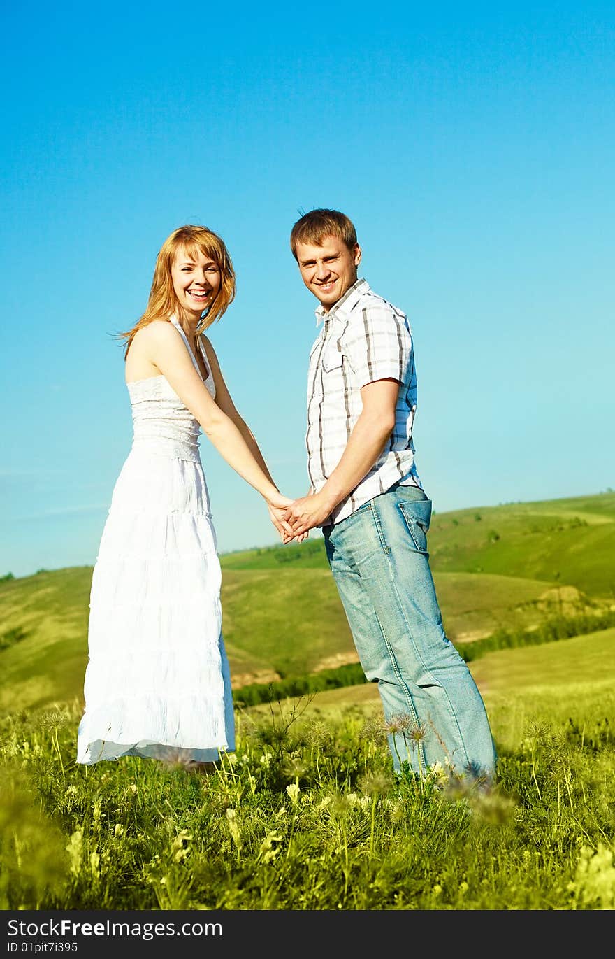 Happy young loving couple spending time outdoor in summertime. Happy young loving couple spending time outdoor in summertime