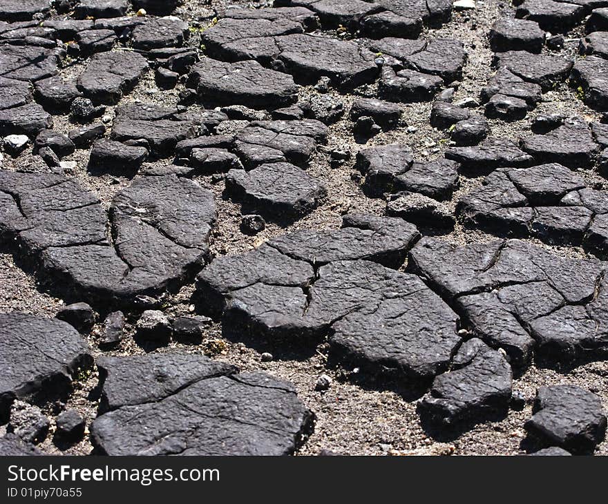 Pieces of old cracked bitumen surface. Pieces of old cracked bitumen surface