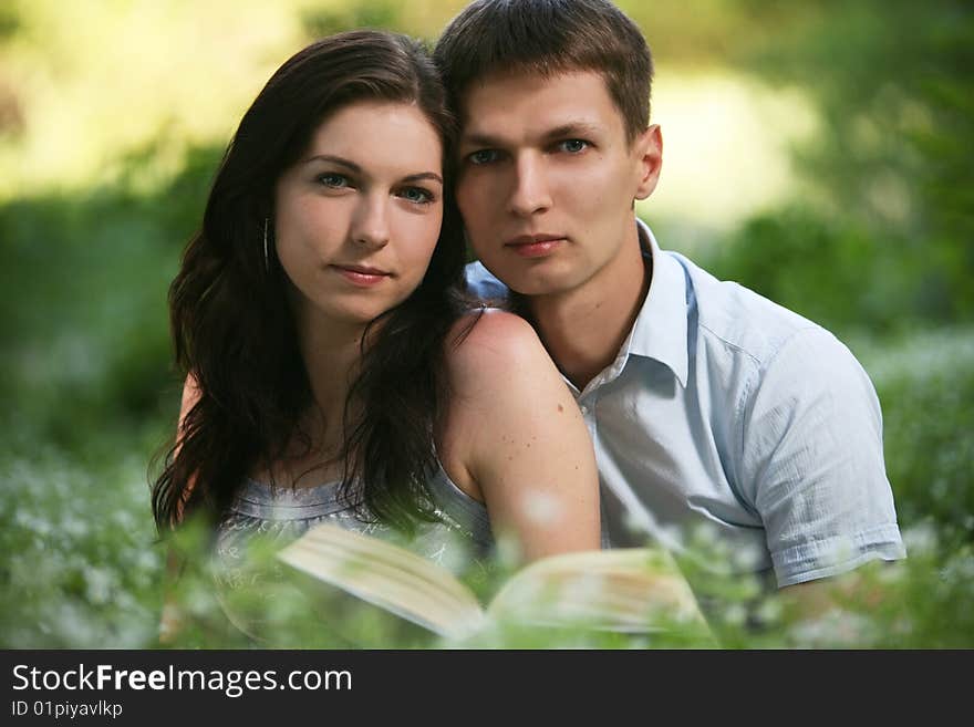 Man and woman sitting on the grass and reading. Man and woman sitting on the grass and reading.