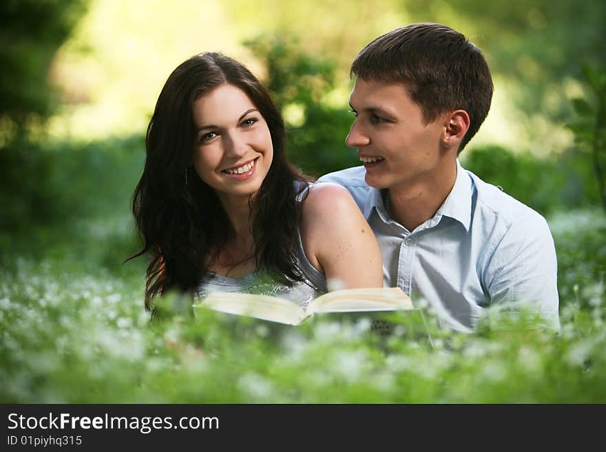 Man and woman sitting on the grass and reading. Man and woman sitting on the grass and reading.