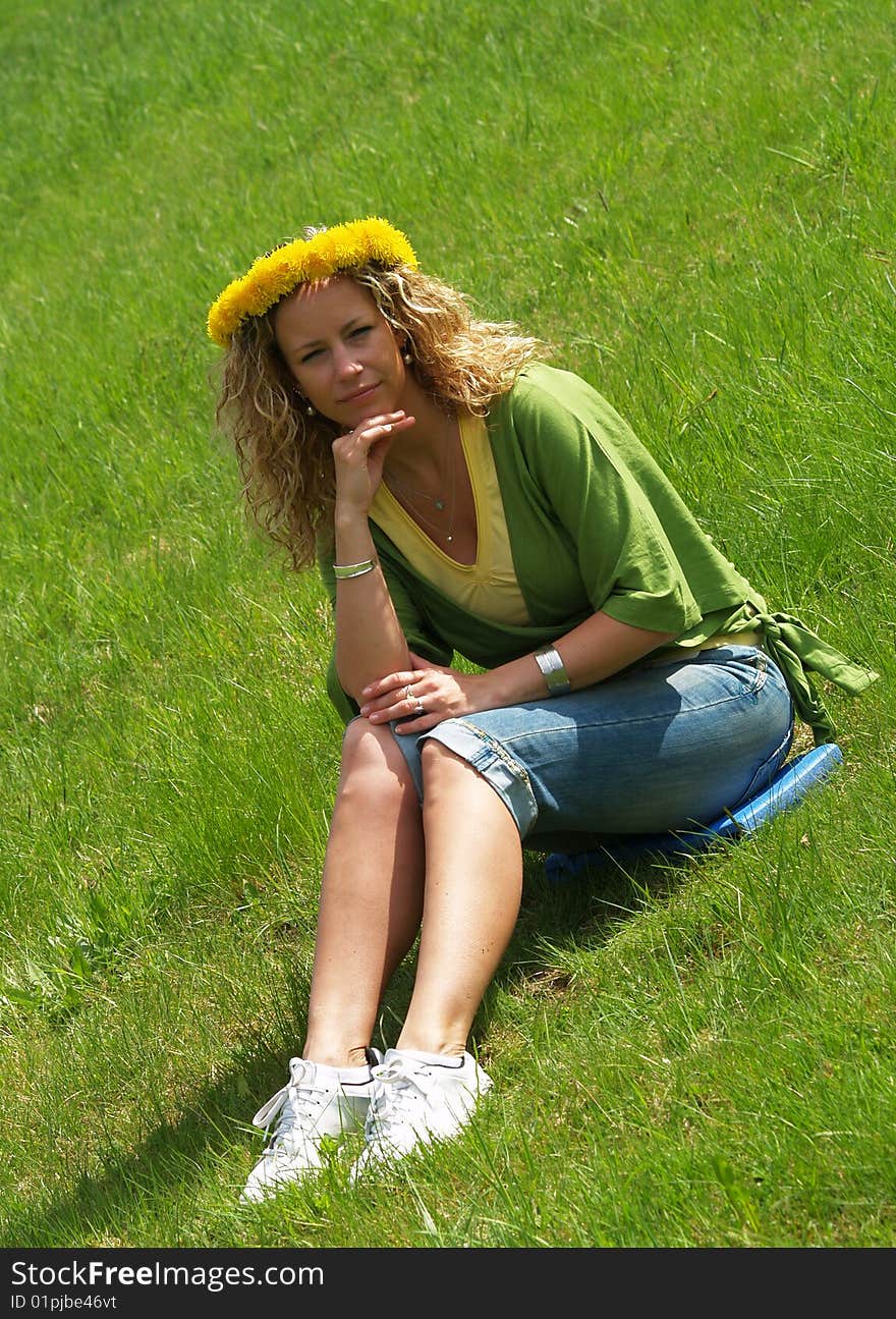 Curly girl with dandelion chain on head