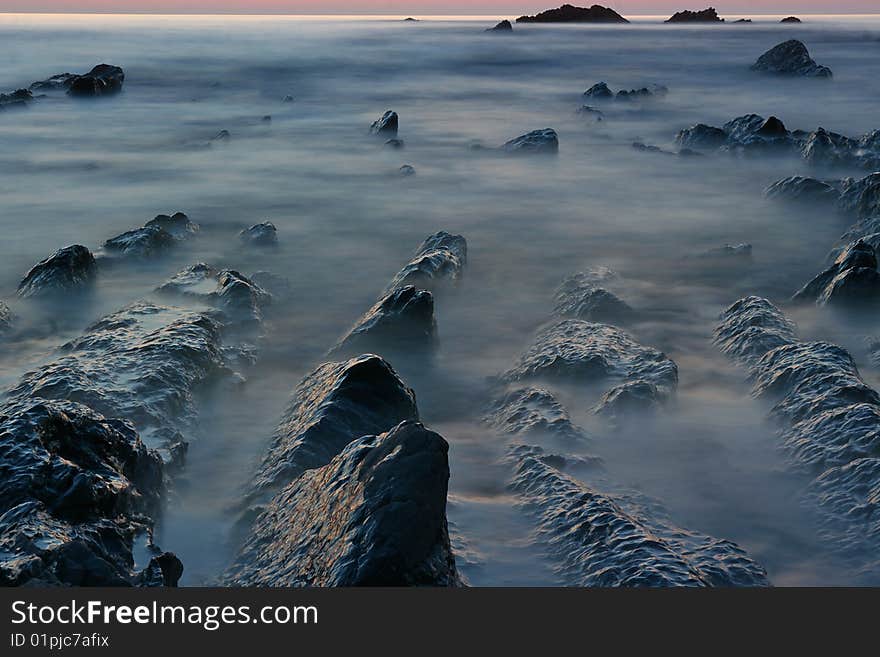 A misterious image of coast water and rocks at night time. A misterious image of coast water and rocks at night time