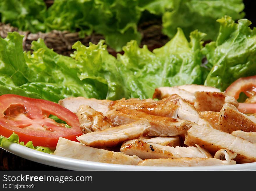 Plate of meat with tomato and lettuce. Plate of meat with tomato and lettuce