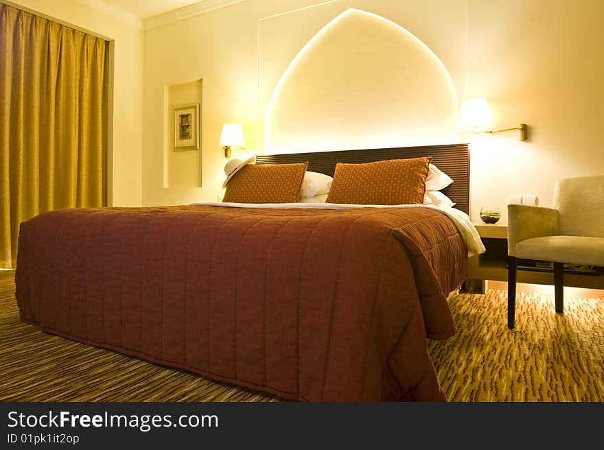 Inside of a luxurious hotel room with a Panama hat on the bed.