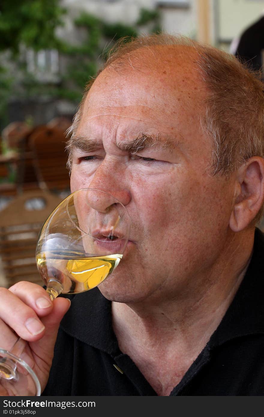 Mature man enjoying a glass of white wine. Mature man enjoying a glass of white wine