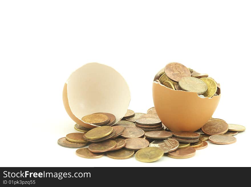 The coins in a egg. Close up. White background. The coins in a egg. Close up. White background