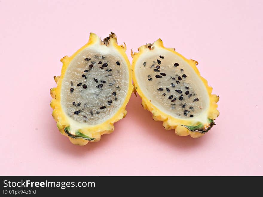 Yellow dragon fruit sections isolated on pink background