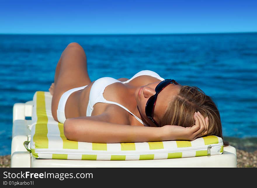 Beautiful young woman lying down On The Beach. Beautiful young woman lying down On The Beach