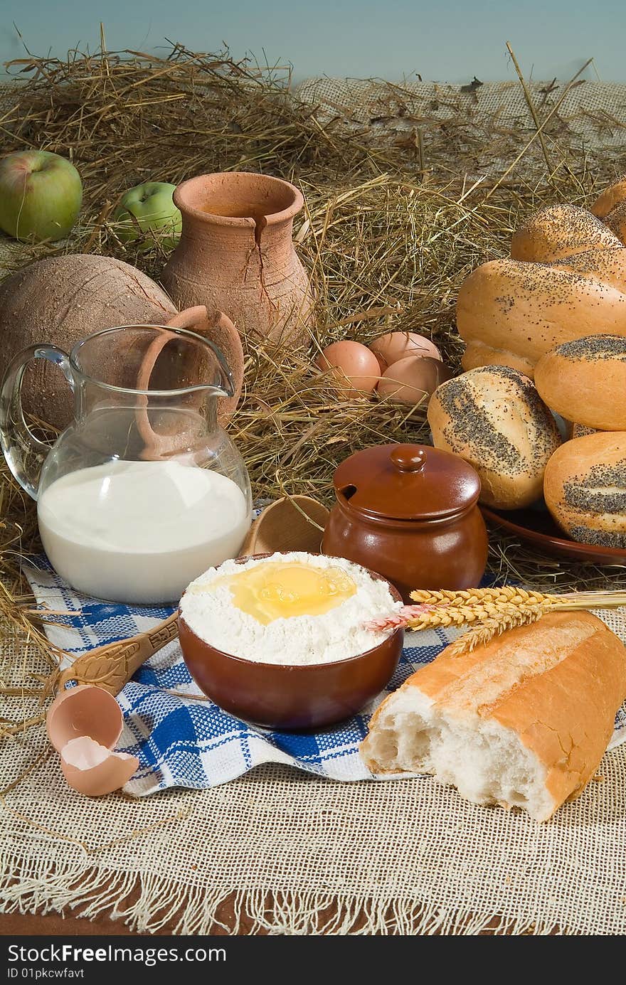 Bread, milk, ceramic on canvas tablecloth. Bread, milk, ceramic on canvas tablecloth