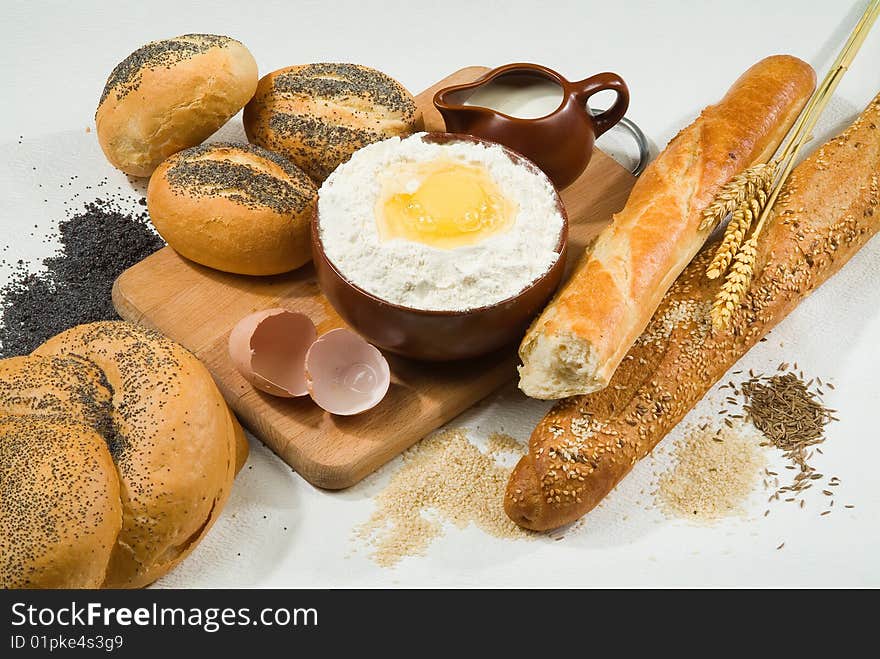 Bread, milk, ceramic on canvas tablecloth. Bread, milk, ceramic on canvas tablecloth