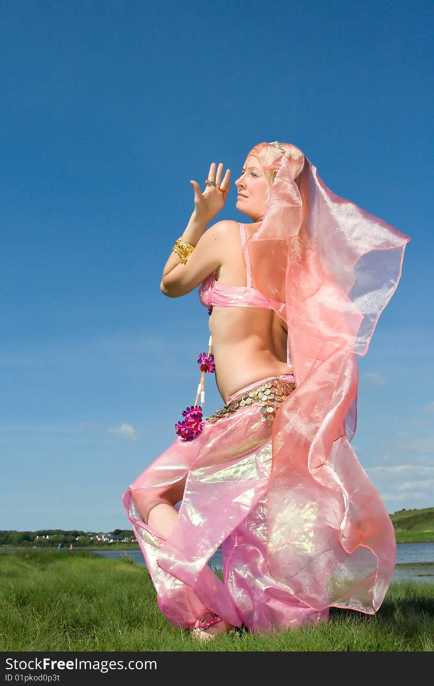 A woman in pink dancing on the grass