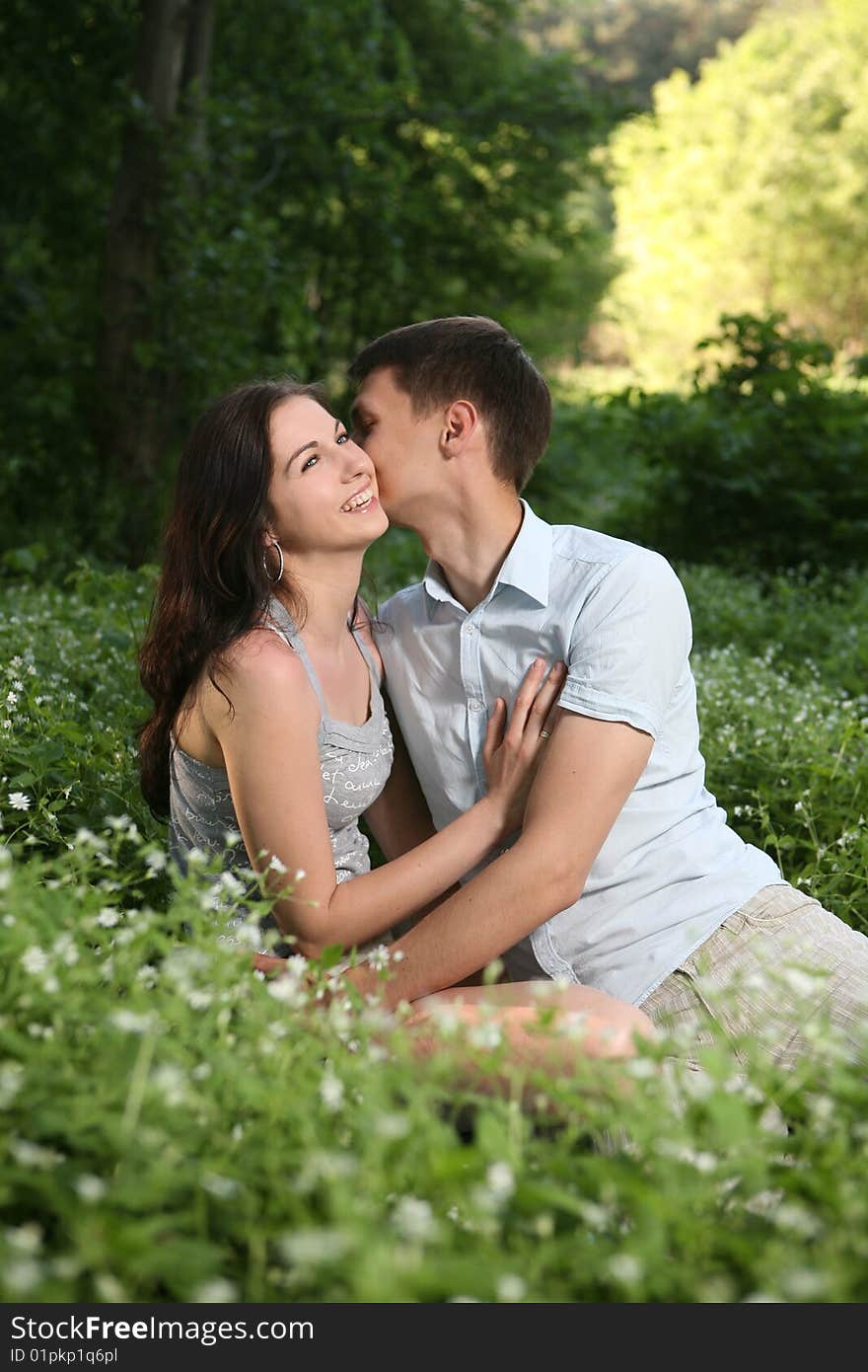 Man and woman sitting on the grass. Looking up. Man and woman sitting on the grass. Looking up.