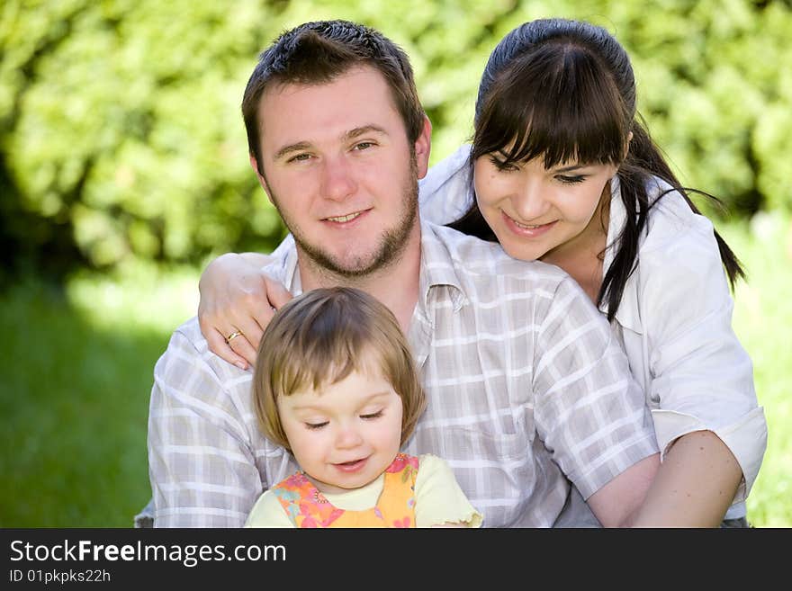 Mother, father and daughter relaxing together on grass. Mother, father and daughter relaxing together on grass