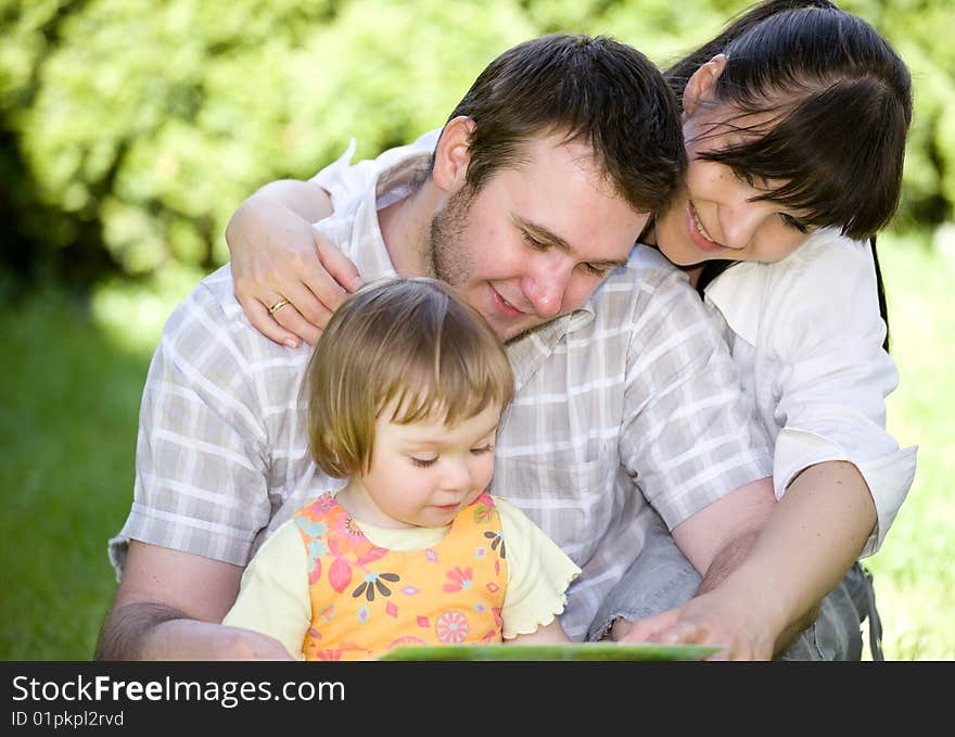 Mother, father and daughter relaxing together on grass. Mother, father and daughter relaxing together on grass