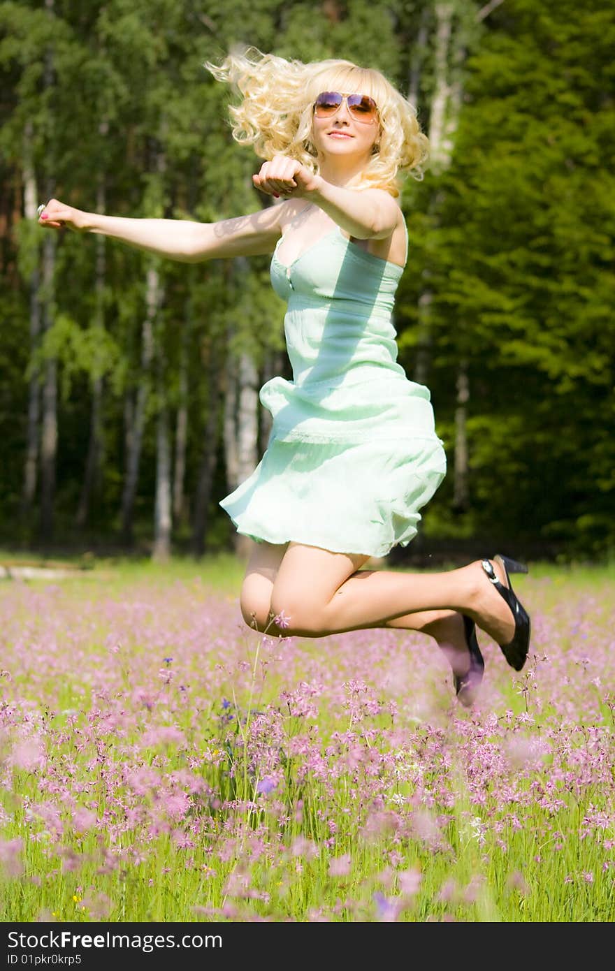 Young woman in pink flowers jumping