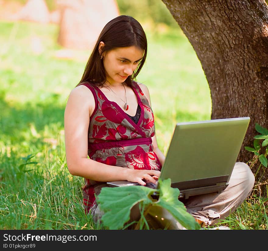 Happy young woman using her laptop outdoors. Happy young woman using her laptop outdoors.