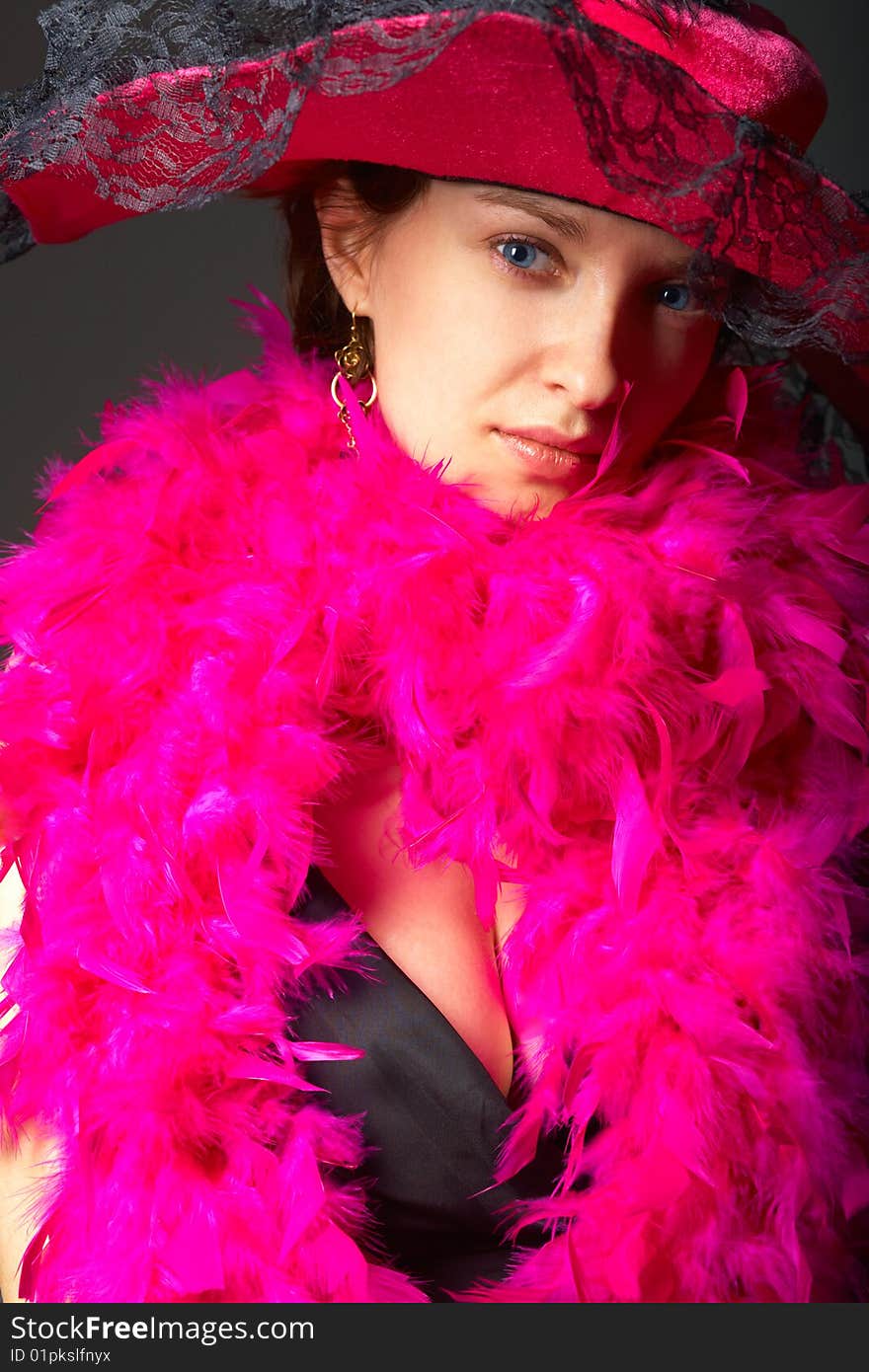 Beautiful woman in pink feathers and hat. Close-up view