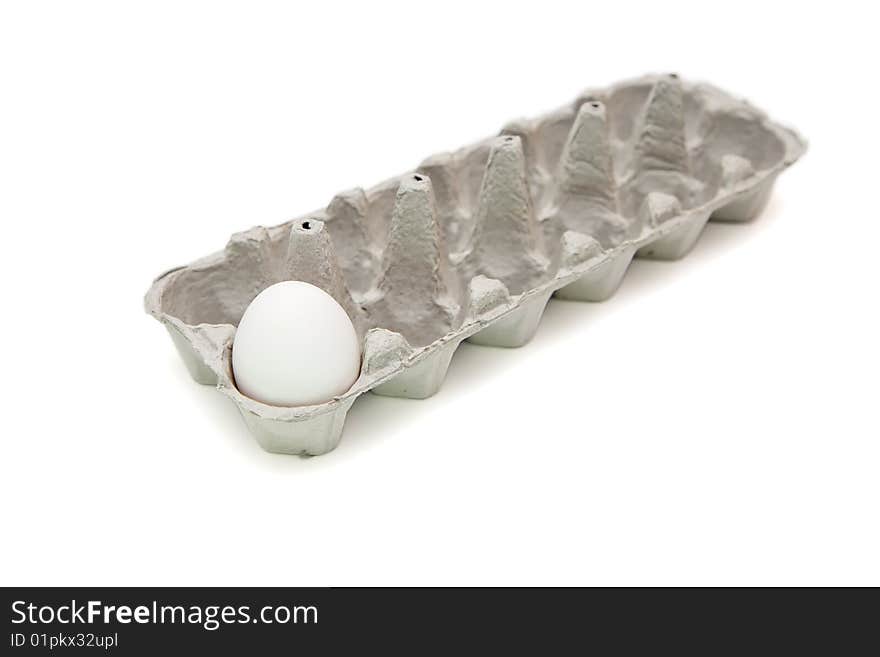 Single white egg in paper box isolated