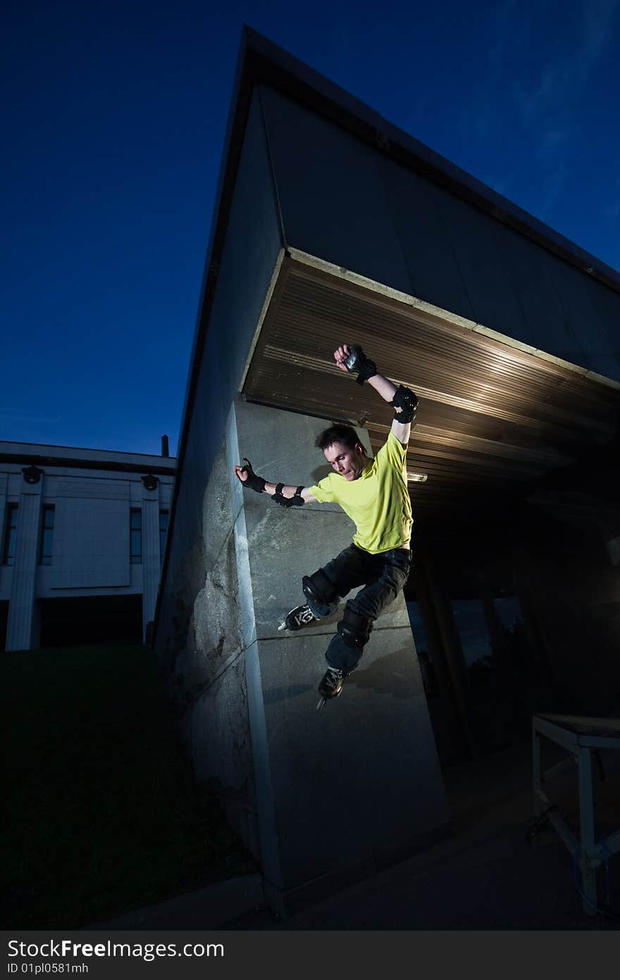 Wide angle photo of a roller performing wall-ride element - photo with a little natural motion blur. Wide angle photo of a roller performing wall-ride element - photo with a little natural motion blur