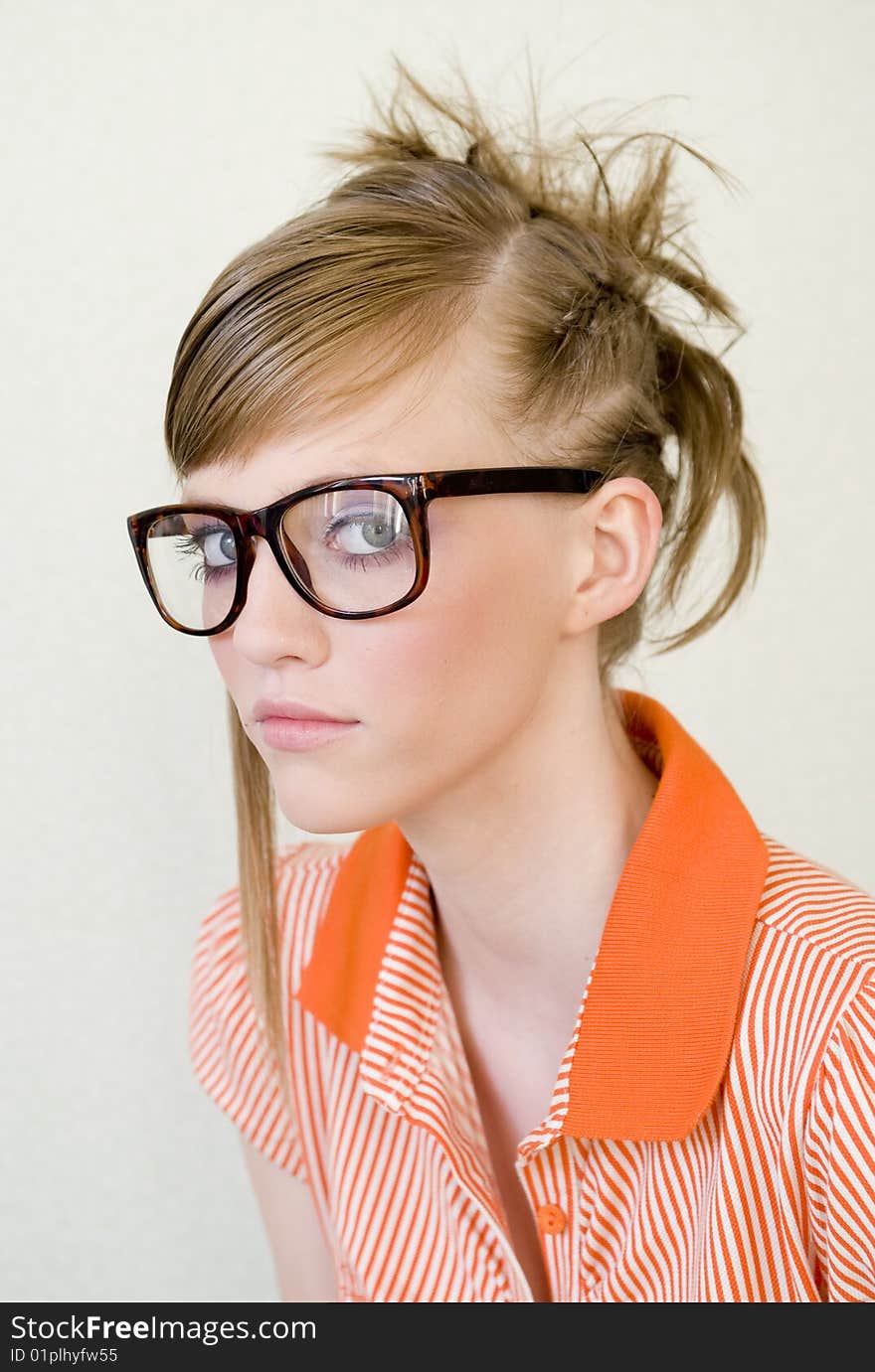 Cute girl wears designer glasses on light background. Cute girl wears designer glasses on light background