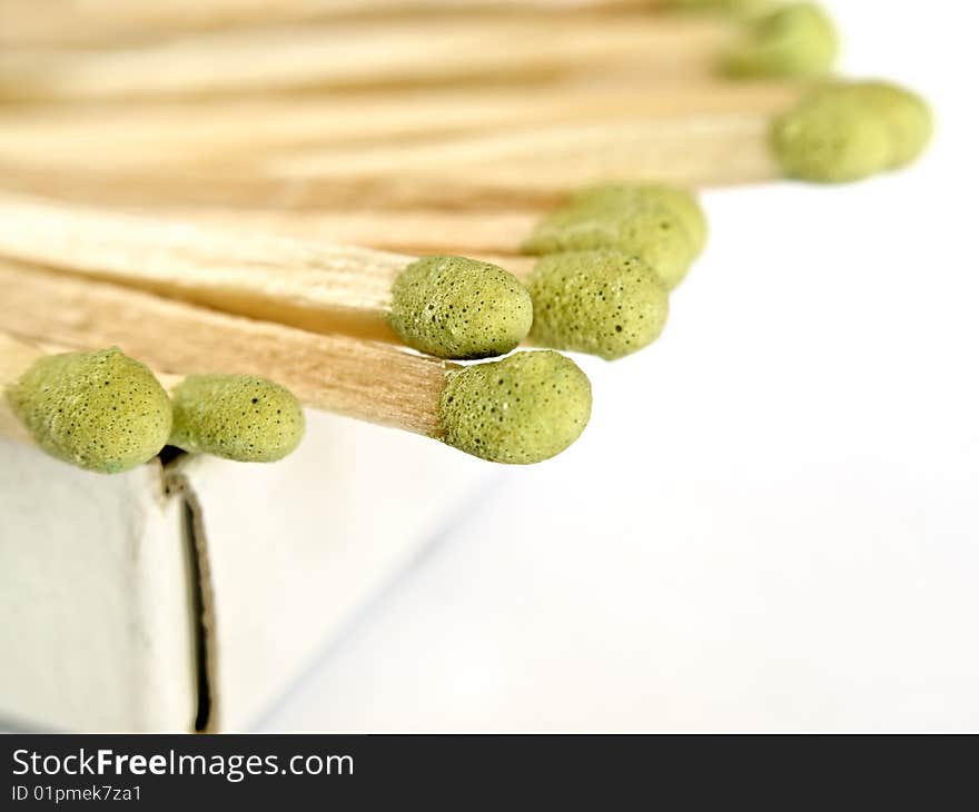 Matches sticking out of the matchbox, macro shot over white background with copy space, shallow DOF