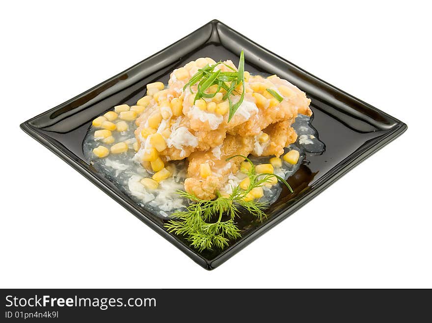 Black plate with pangasius under corns sauce