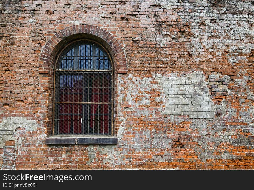 Old barred window in battered old wall with interesting texture. Old barred window in battered old wall with interesting texture