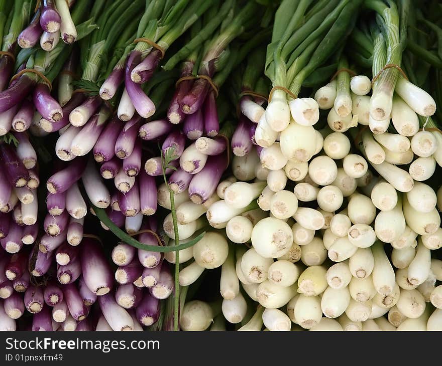 Purple and white welch onions at the market