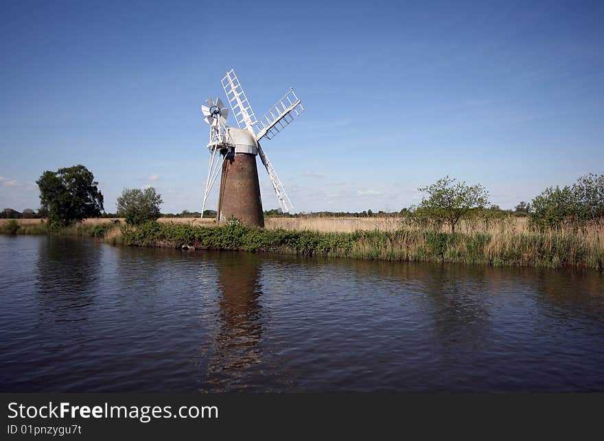 Traditional windmill by a river.