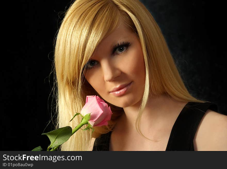 The beautiful girl with a flowing hair and a rose