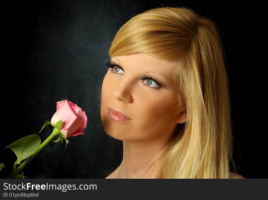 The beautiful girl with a flowing hair and a rose