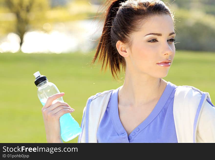 Young woman drinking water at outdoors workout