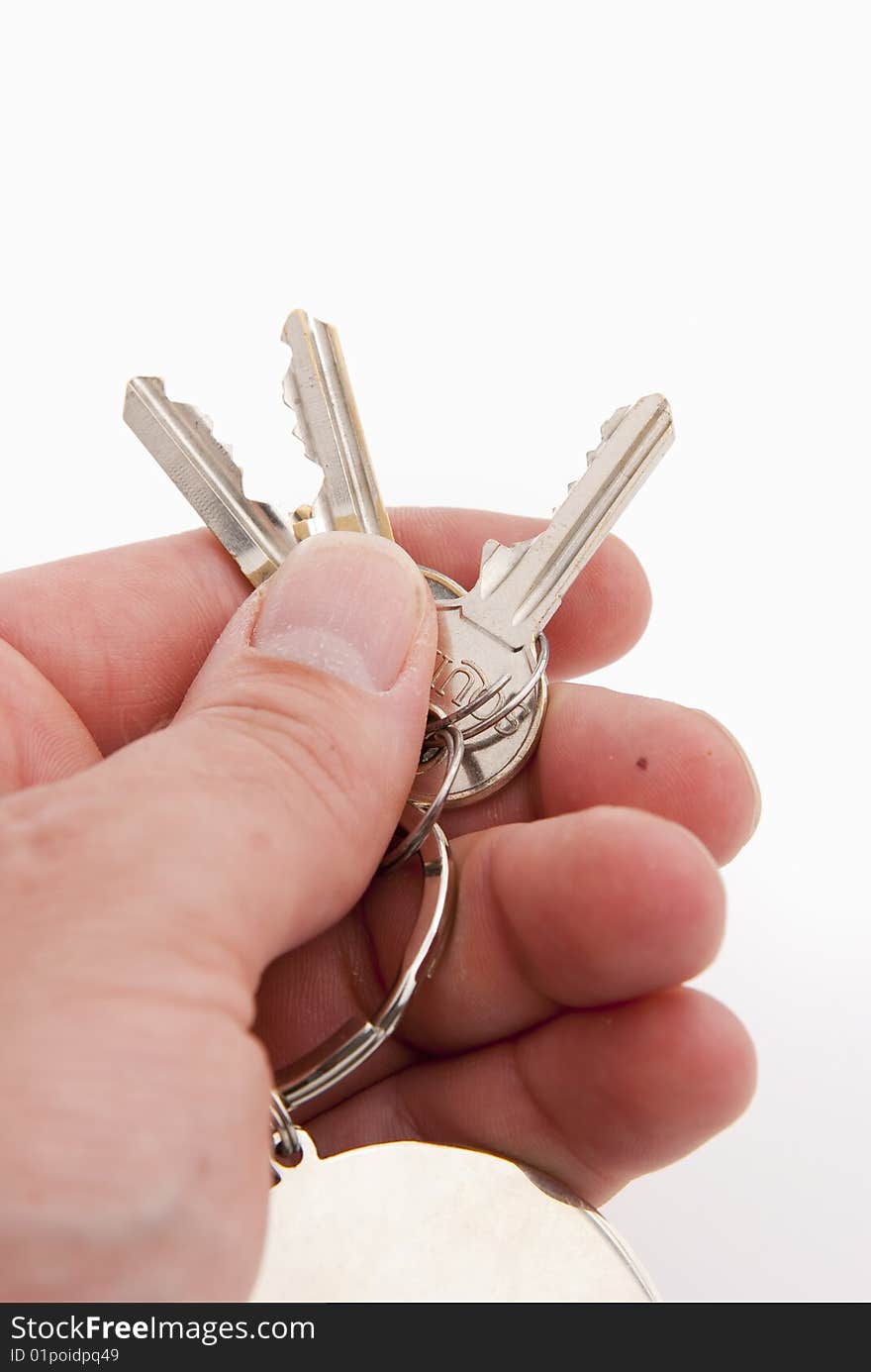 Hand holding keys isolated over white background