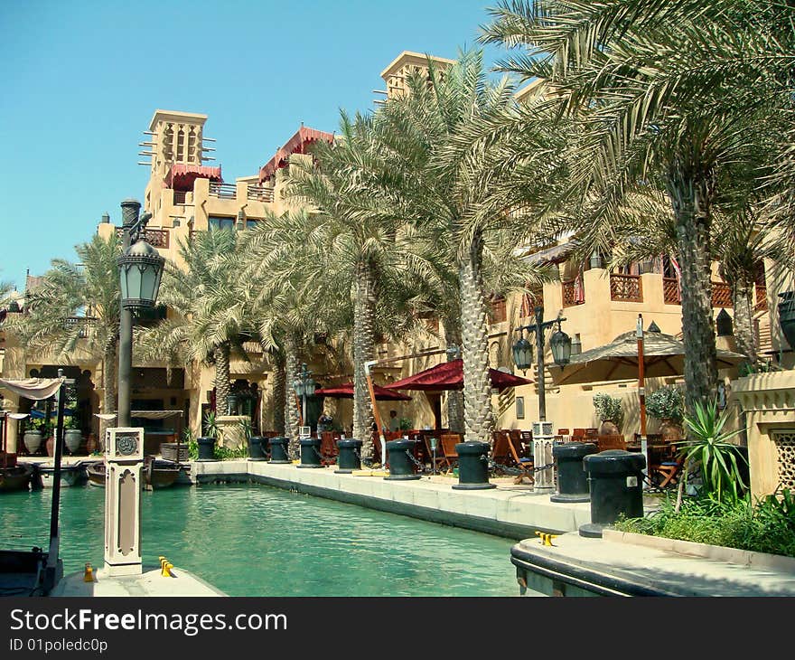 Palm trees lining the walkway at the Madinat Jumeirah with restaurants along the side. Palm trees lining the walkway at the Madinat Jumeirah with restaurants along the side