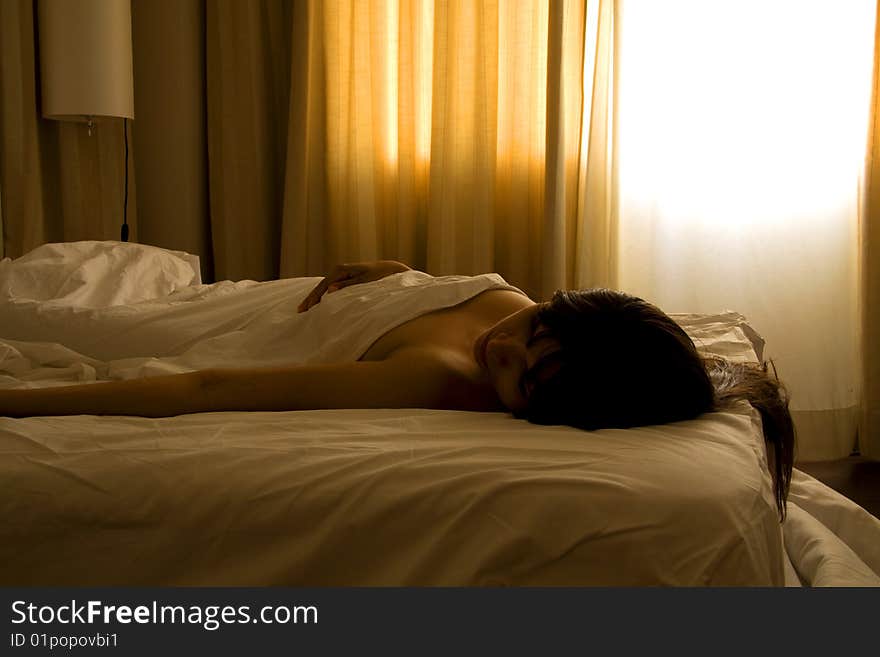 Woman sleeping with only the bed sheet covering her body. Woman sleeping with only the bed sheet covering her body