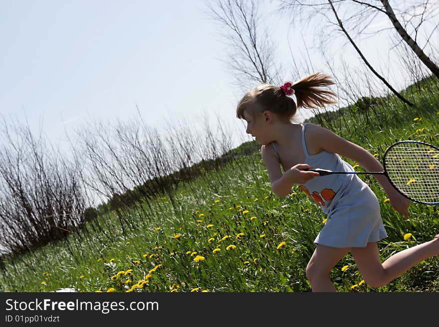 The running girl with badminton racket in park