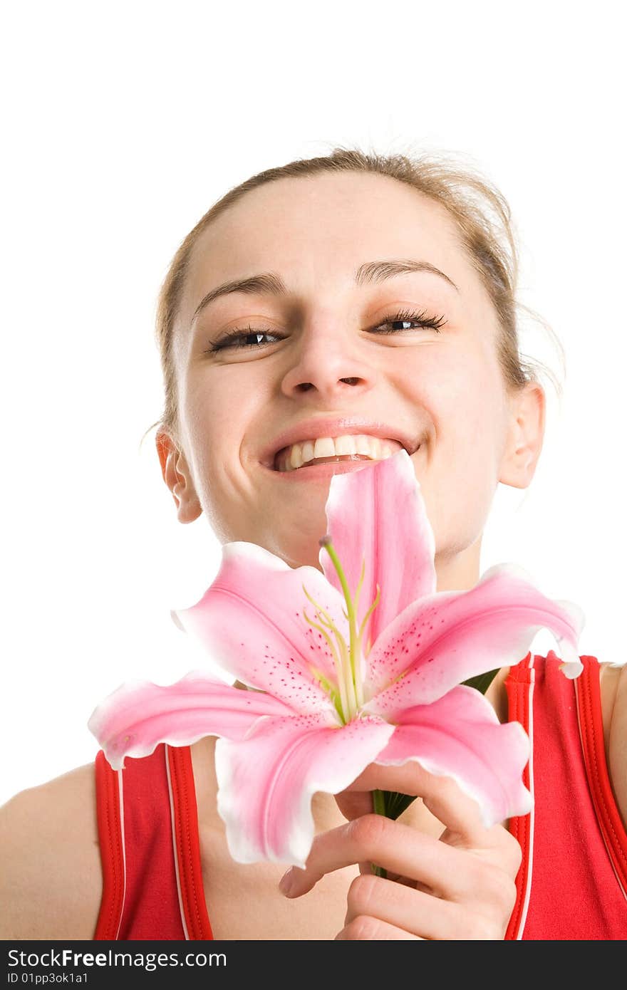 A smiling nice blond girl in red posing with a pink lily near her face on a white background. A smiling nice blond girl in red posing with a pink lily near her face on a white background