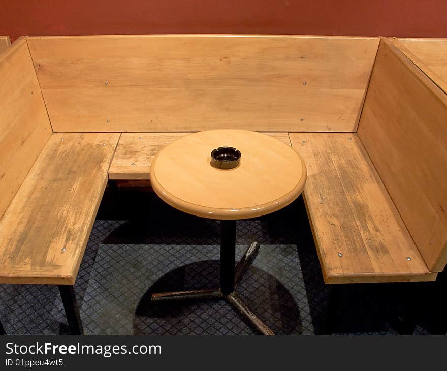 Plunk bench and round wooden table with ashtray in cafe. Plunk bench and round wooden table with ashtray in cafe