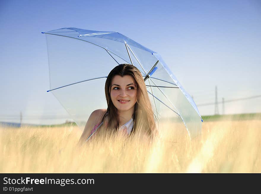 Smiling girl in field with umbrella. Smiling girl in field with umbrella