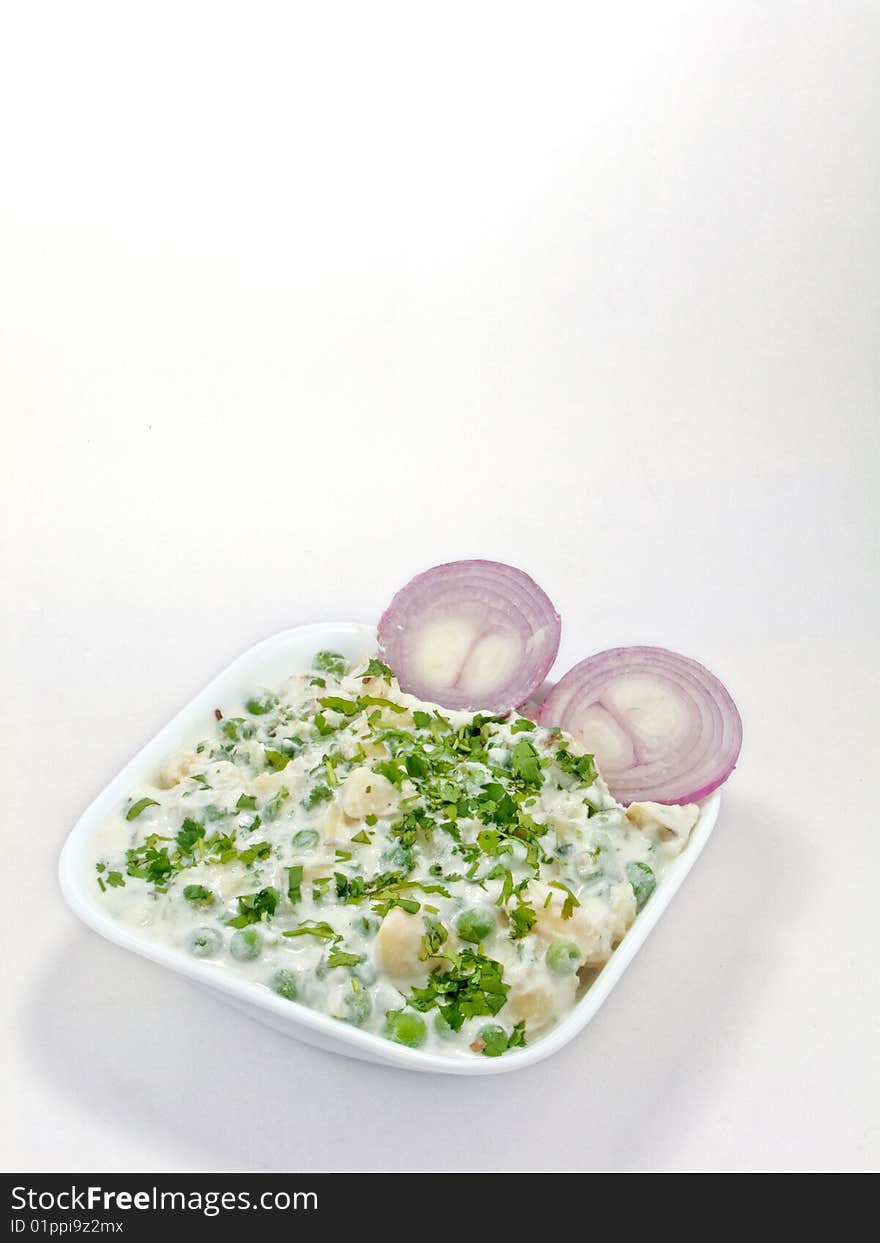 Baked vegetable in a white bowl and two onion