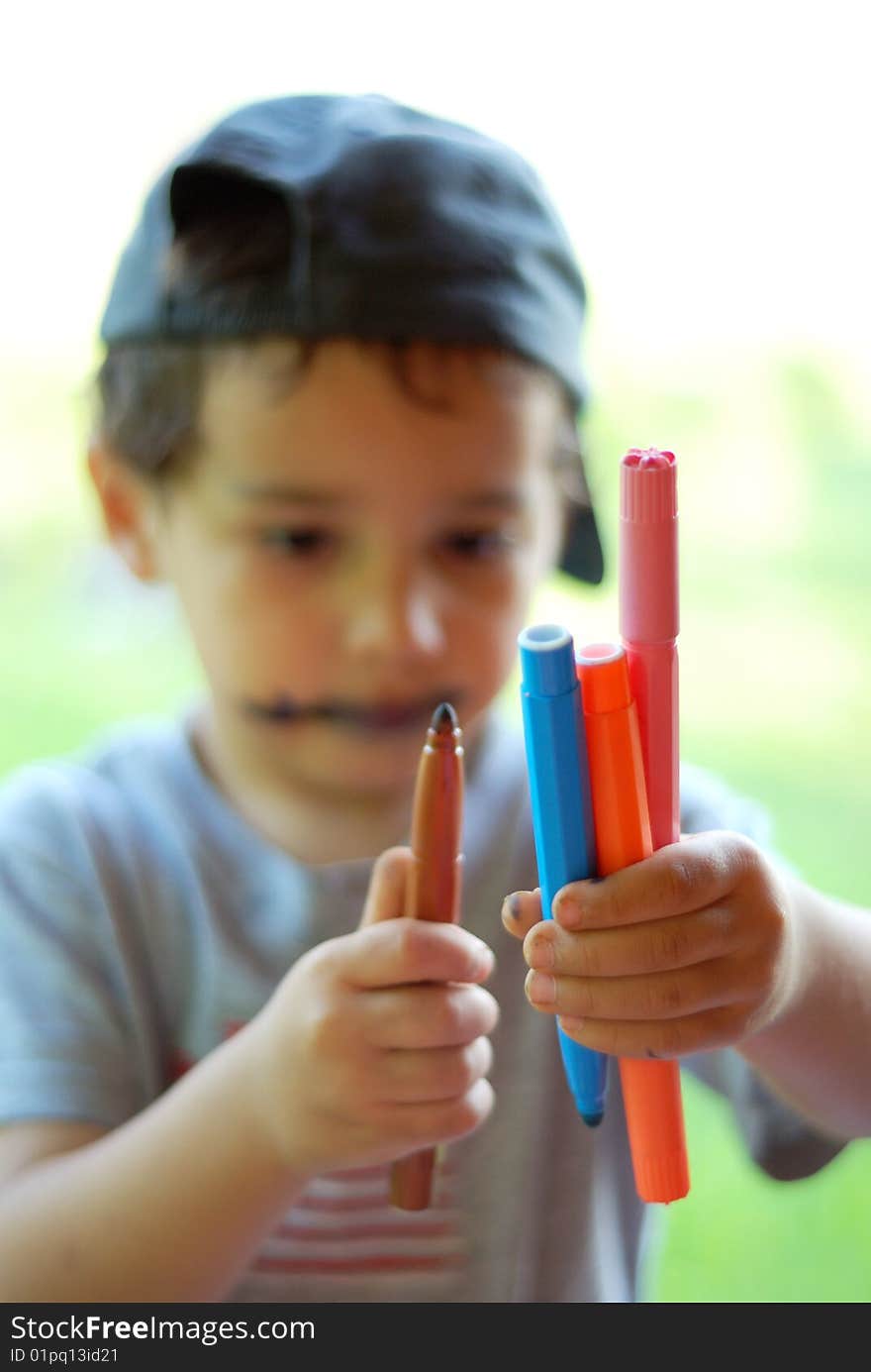 A little kid with colors in his hands. A little kid with colors in his hands.