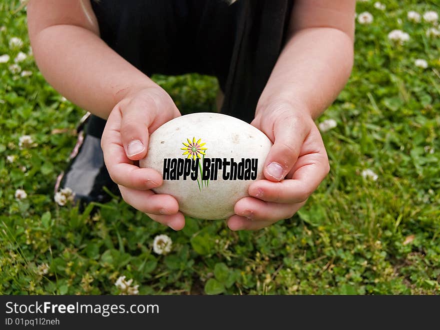 Little girl holding a goose egg with birthday message. Little girl holding a goose egg with birthday message.