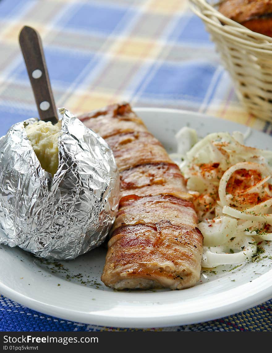 Grilled meat served with potato and onion. Grilled meat served with potato and onion