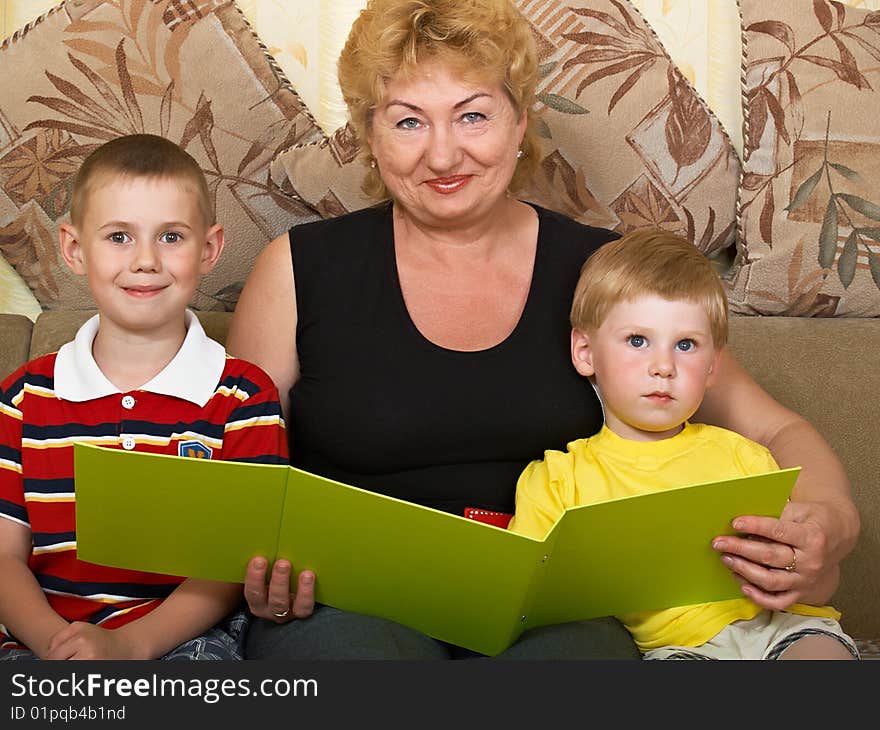 Young grandmother with two grandchildren at home on the couch. Young grandmother with two grandchildren at home on the couch