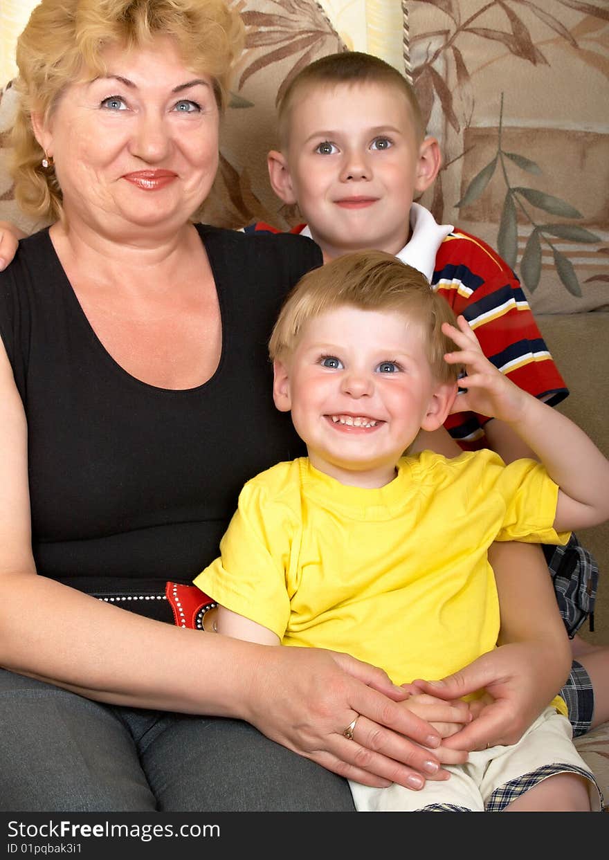 Young grandmother with two grandchildren at home on the couch. Young grandmother with two grandchildren at home on the couch