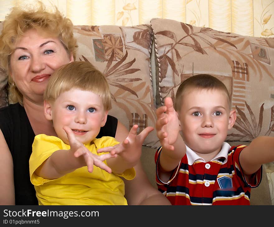 Young grandmother with two grandchildren at home on the couch. Young grandmother with two grandchildren at home on the couch