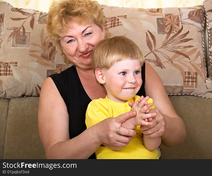 Young grandmother with grandchildren at home on the couch. Young grandmother with grandchildren at home on the couch