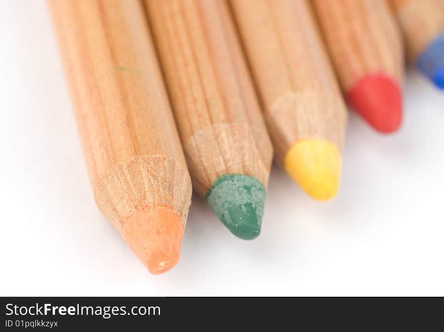 Colored wooden pencils on white background with shadows. Soft focus. Colored wooden pencils on white background with shadows. Soft focus.